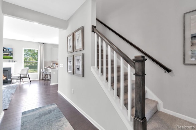 2768 Silo Dr, Saline, MI 48176 - staircase with wood finished floors and a glass covered fireplace