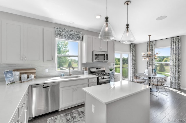 2768 Silo Dr, Saline, MI 48176 - kitchen featuring stainless steel appliances, backsplash, a center island, a chandelier, and dark wood finished floors