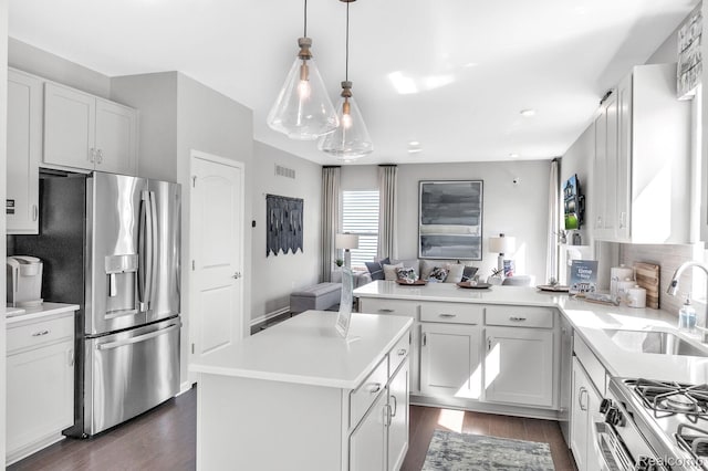 2768 Silo Dr, Saline, MI 48176 - kitchen with stainless steel appliances, a peninsula, dark wood-type flooring, light countertops, and open floor plan