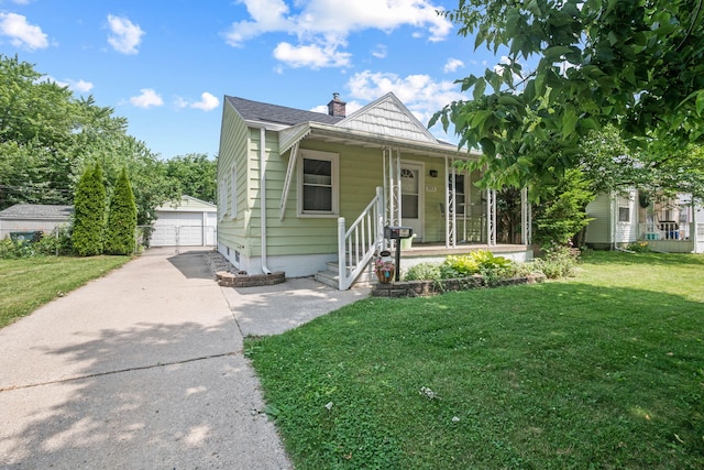 352 W Tacoma St, Clawson, MI 48017 - view of front of home with covered porch, an outbuilding, a garage, a front lawn, and a chimney