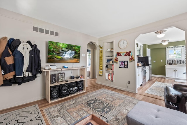 352 W Tacoma St, Clawson, MI 48017 - living area featuring arched walkways, light wood-style floors, and built in features