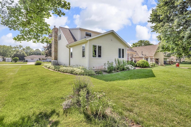 3416 Northlands Ave, Jackson, MI 49201 - view of side of property with a chimney, a lawn, and a shingled roof
