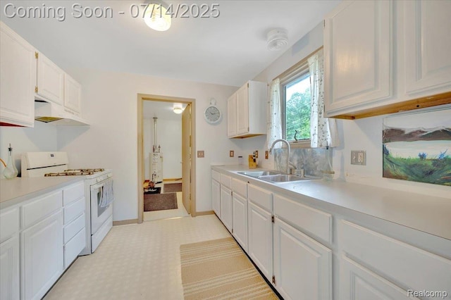 3117 Maumee Trl, Clyde, MI 48049 - kitchen featuring white range with gas stovetop, under cabinet range hood, light countertops, white cabinets, and light floors