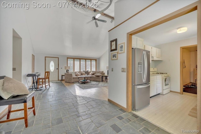 3117 Maumee Trl, Clyde, MI 48049 - kitchen with stainless steel fridge, white range with gas stovetop, under cabinet range hood, ceiling fan, and white cabinets