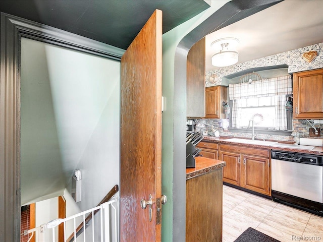 1313 Wall St, Port Huron, MI 48060 - kitchen with dishwasher, brown cabinets, arched walkways, and backsplash