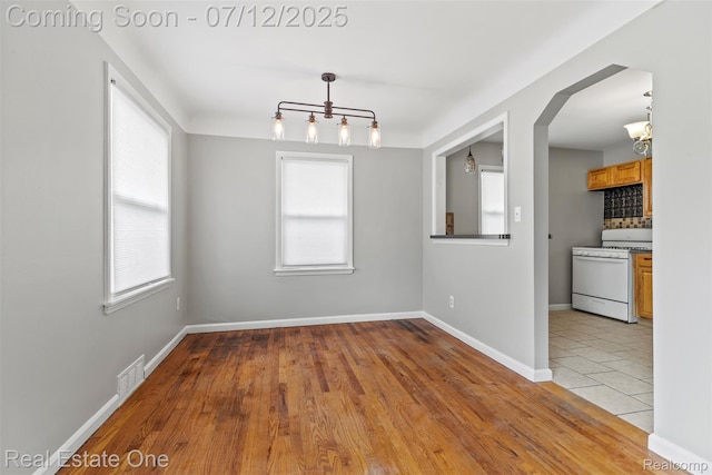 14268 Trenton Rd, Southgate, MI 48195 - unfurnished dining area with a chandelier, healthy amount of natural light, and arched walkways