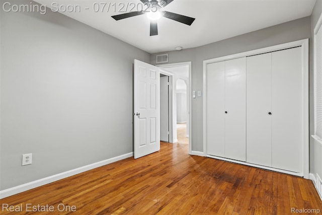 14268 Trenton Rd, Southgate, MI 48195 - unfurnished bedroom with wood finished floors, a closet, arched walkways, and a ceiling fan