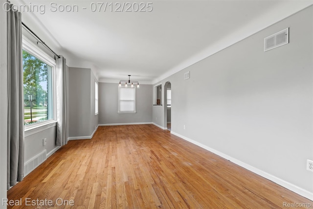 14268 Trenton Rd, Southgate, MI 48195 - empty room featuring a chandelier, light wood-style flooring, and arched walkways
