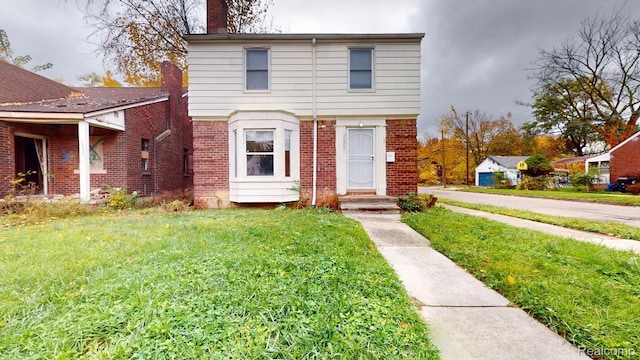 10800 Stratman St, Detroit, MI 48224 - colonial-style house with brick siding, a front lawn, and a chimney