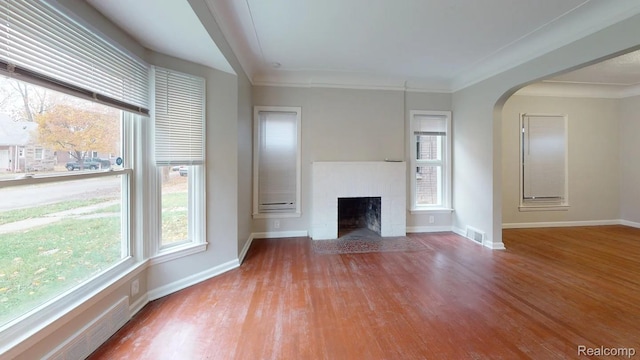 10800 Stratman St, Detroit, MI 48224 - unfurnished living room featuring wood finished floors, arched walkways, and a fireplace
