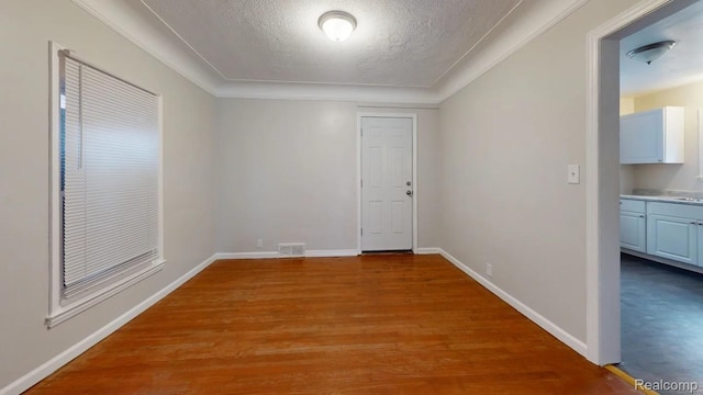 10800 Stratman St, Detroit, MI 48224 - unfurnished room with a textured ceiling, light wood-style floors, and ornamental molding
