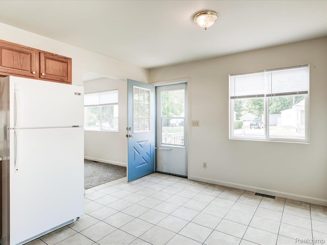 1114 Union St, Port Huron, MI 48060 - kitchen featuring freestanding refrigerator, brown cabinetry, and light tile patterned flooring