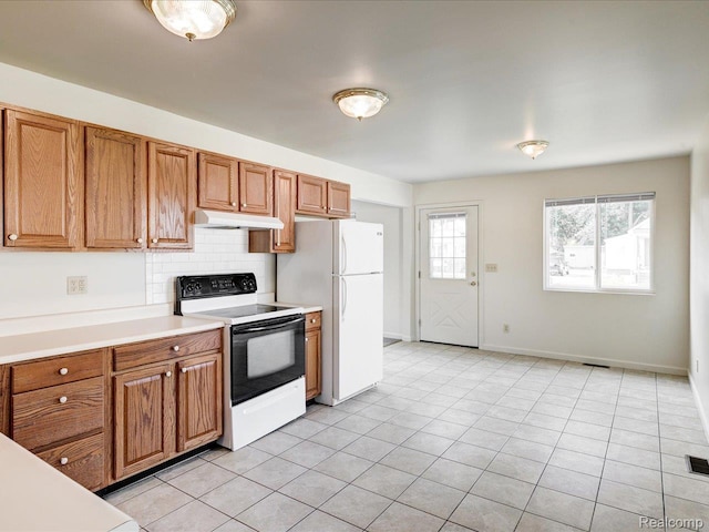 1114 Union St, Port Huron, MI 48060 - kitchen with range with electric cooktop, under cabinet range hood, freestanding refrigerator, brown cabinetry, and light countertops