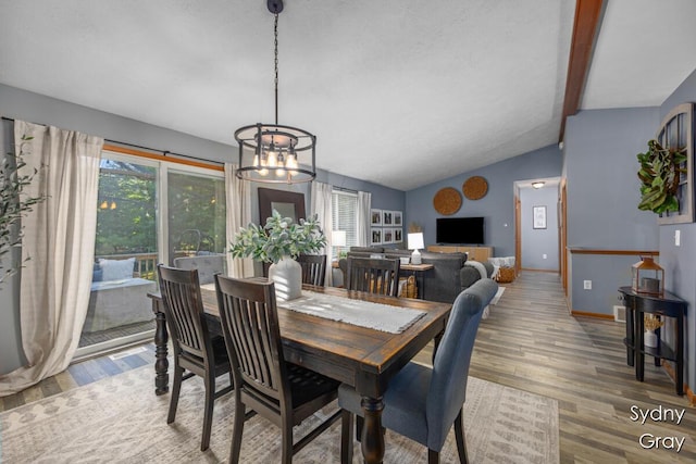 11200 Ivory Valley Dr NE, Rockford, MI 49341 - dining area featuring wood finished floors, a chandelier, and vaulted ceiling