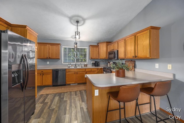 11200 Ivory Valley Dr NE, Rockford, MI 49341 - kitchen with stainless steel appliances, a peninsula, brown cabinetry, light countertops, and lofted ceiling