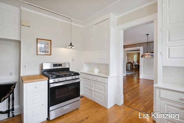 120 Union Ave SE, Grand Rapids, MI 49503 - kitchen featuring stainless steel range with gas stovetop, light wood-type flooring, white cabinetry, and decorative light fixtures