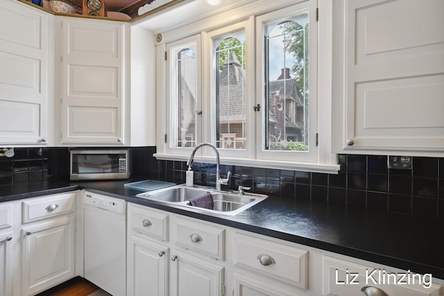 120 Union Ave SE, Grand Rapids, MI 49503 - kitchen with white dishwasher, stainless steel microwave, dark countertops, and white cabinetry
