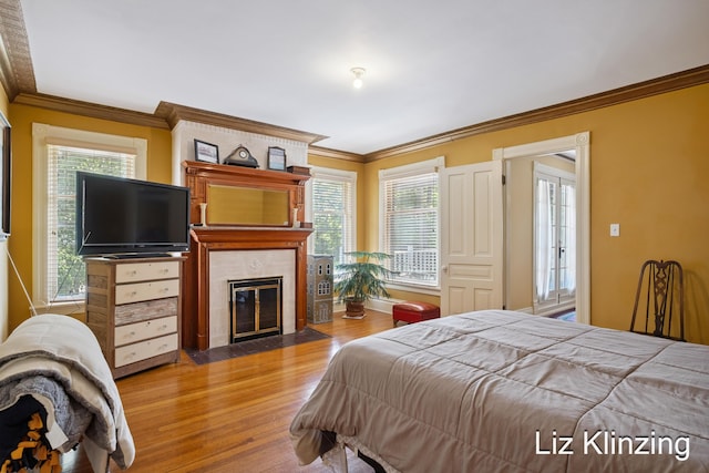120 Union Ave SE, Grand Rapids, MI 49503 - bedroom featuring wood finished floors, ornamental molding, a fireplace, and multiple windows