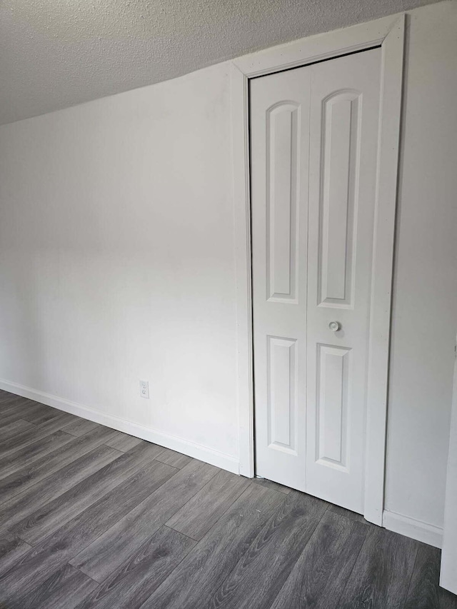 538 Whitney Ave, Morenci, MI 49256 - unfurnished bedroom featuring dark wood-style flooring, a closet, and a textured ceiling