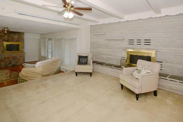 2357 River St, Kalamazoo, MI 49048 - living area featuring a glass covered fireplace, beamed ceiling, ceiling fan, and carpet