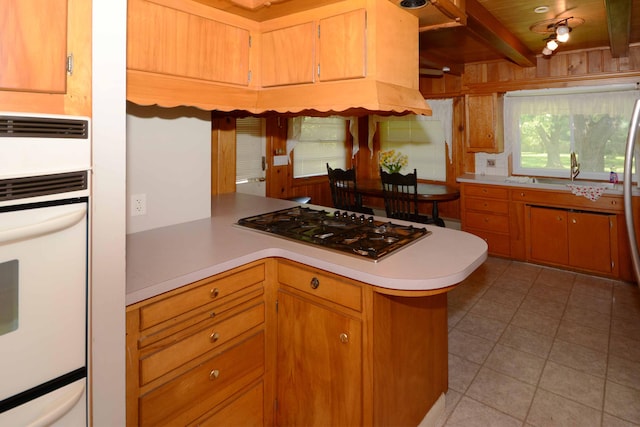 2357 River St, Kalamazoo, MI 49048 - kitchen with stainless steel gas stovetop, white oven, light countertops, light tile patterned floors, and a peninsula