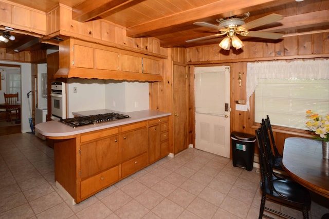 2357 River St, Kalamazoo, MI 49048 - kitchen with stainless steel gas cooktop, ceiling fan, light countertops, wooden walls, and oven