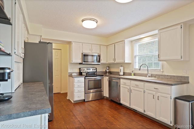 622 W Schleier St, Frankenmuth, MI 48734 - kitchen with stainless steel appliances, white cabinetry, dark countertops, and dark wood-type flooring