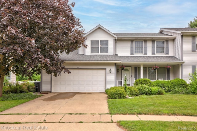 622 W Schleier St, Frankenmuth, MI 48734 - view of front of home with covered porch, a front lawn, a garage, driveway, and a shingled roof