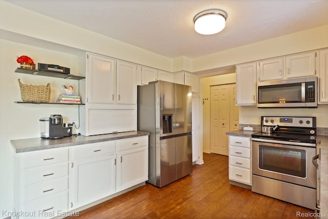 622 W Schleier St, Frankenmuth, MI 48734 - kitchen with appliances with stainless steel finishes, dark wood-type flooring, white cabinetry, and open shelves