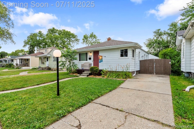 24528 Schroeder Ave, Eastpointe, MI 48021 - view of front of home with a chimney, driveway, a front lawn, and a gate