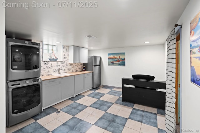 24528 Schroeder Ave, Eastpointe, MI 48021 - kitchen with stacked washer / dryer, freestanding refrigerator, gray cabinets, recessed lighting, and butcher block countertops