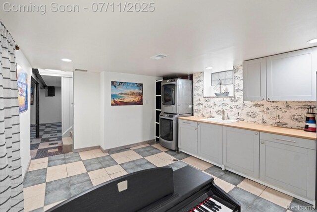 24528 Schroeder Ave, Eastpointe, MI 48021 - kitchen featuring stacked washer and clothes dryer, wooden counters, recessed lighting, and white cabinetry