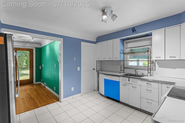 18930 Deering St, Melvindale, MI 48152 - kitchen with dishwashing machine, freestanding refrigerator, white cabinets, and healthy amount of natural light