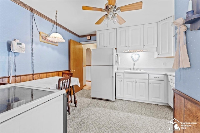 1508 12th St, Wyandotte, MI 48192 - kitchen with freestanding refrigerator, white cabinets, ceiling fan, light countertops, and light colored carpet