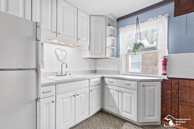 1508 12th St, Wyandotte, MI 48192 - kitchen featuring freestanding refrigerator, wallpapered walls, open shelves, white cabinets, and light countertops