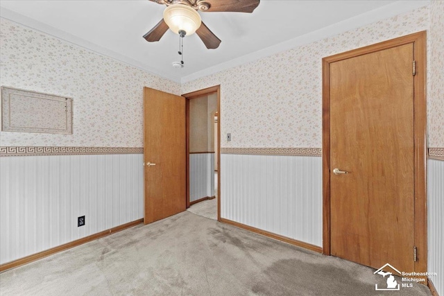 1508 12th St, Wyandotte, MI 48192 - unfurnished bedroom with wallpapered walls, a wainscoted wall, light carpet, and a ceiling fan