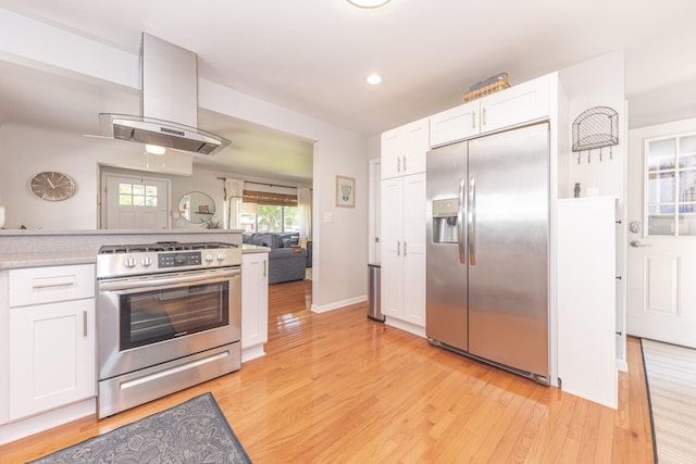 2041 Norfolk Ave, Ann Arbor, MI 48103 - kitchen featuring appliances with stainless steel finishes, extractor fan, light wood-style flooring, white cabinets, and recessed lighting