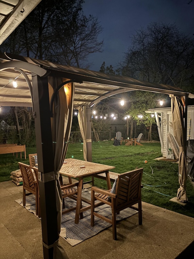 2041 Norfolk Ave, Ann Arbor, MI 48103 - patio at night with outdoor dining area, a patio area, and a yard