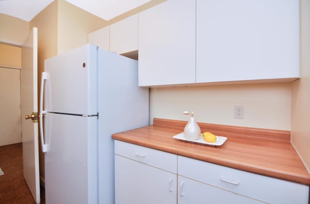 609 Watersedge Dr, Ann Arbor, MI 48105 - kitchen featuring freestanding refrigerator, white cabinets, and light countertops