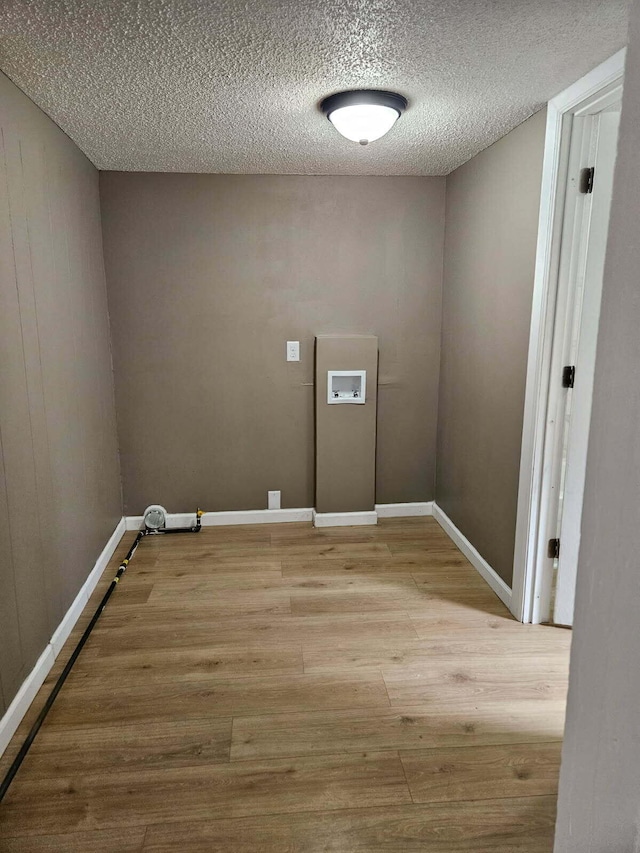 4084 Seneca St, Weston, MI 49289 - laundry room featuring hookup for a washing machine, light wood-type flooring, and a textured ceiling