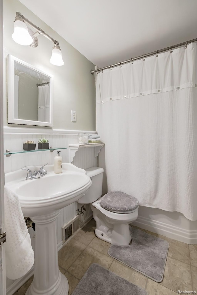 3070 Old Orchard Dr, Waterford, MI 48328 - bathroom with a wainscoted wall and shower / tub combo with curtain