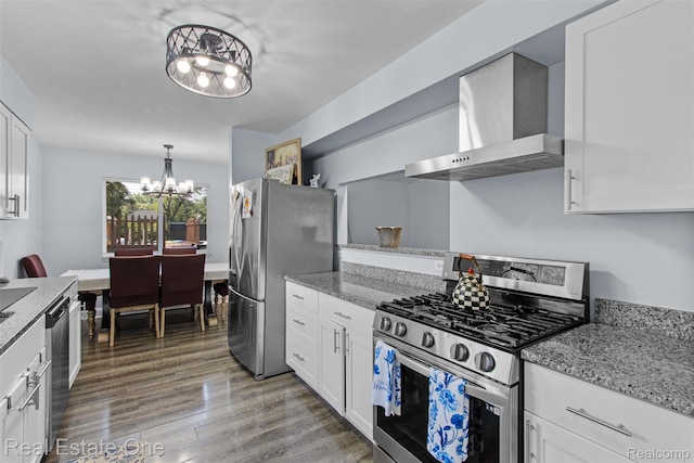 2930 Wisconsin Rd, Troy, MI 48083 - kitchen featuring appliances with stainless steel finishes, wall chimney range hood, a chandelier, white cabinets, and light wood-style flooring