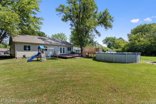 2930 Wisconsin Rd, Troy, MI 48083 - view of green lawn with a playground, a deck, and an outdoor pool
