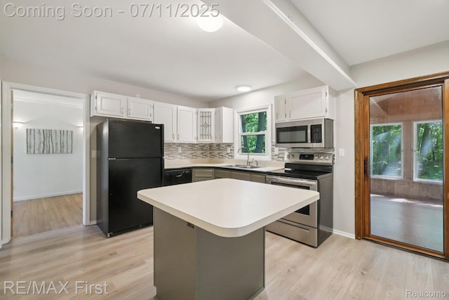 5910 Hillsboro Rd, Davisburg, MI 48350 - kitchen with appliances with stainless steel finishes, light wood finished floors, white cabinetry, backsplash, and light countertops