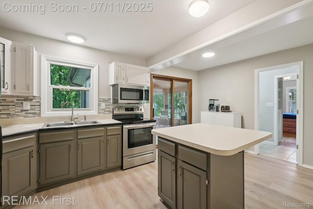 5910 Hillsboro Rd, Davisburg, MI 48350 - kitchen with stainless steel appliances, decorative backsplash, light wood-type flooring, a center island, and light countertops