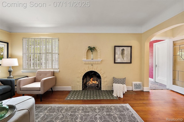 132 Illinois Ave, Pontiac, MI 48341 - living room with wood finished floors, a lit fireplace, and arched walkways