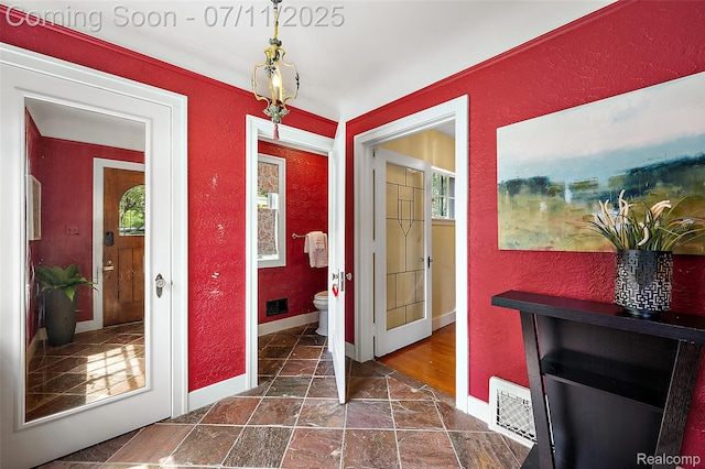 132 Illinois Ave, Pontiac, MI 48341 - hallway with a textured wall, plenty of natural light, and stone tile floors