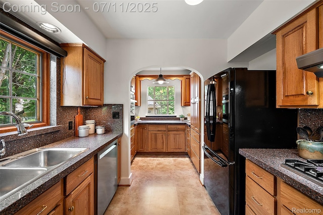 132 Illinois Ave, Pontiac, MI 48341 - kitchen with stainless steel appliances, arched walkways, and brown cabinetry