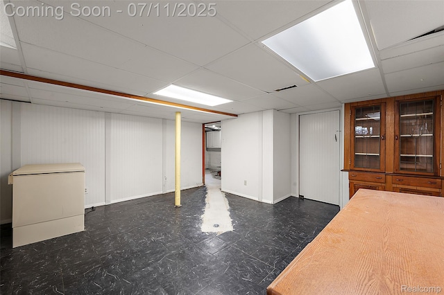 132 Illinois Ave, Pontiac, MI 48341 - finished below grade area with tile patterned floors, refrigerator, and a paneled ceiling