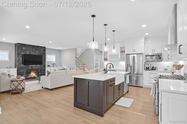 1212 Royal Ave, Royal Oak, MI 48073 - kitchen featuring stainless steel appliances, light countertops, white cabinets, recessed lighting, and wall chimney range hood